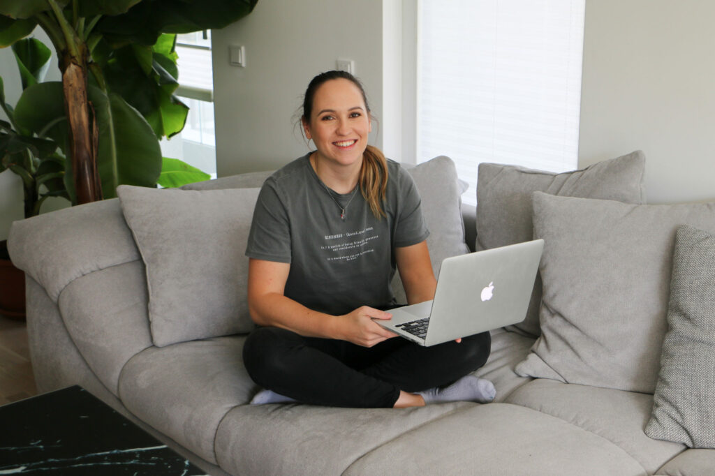 Alexandra Lederer auf einer Couch mit Laptop